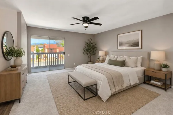 a view of a livingroom with a chandelier fan and windows
