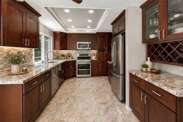 a large kitchen with stainless steel appliances granite countertop a stove refrigerator and a sink