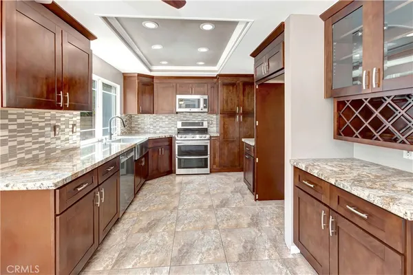 a large kitchen with stainless steel appliances granite countertop a sink stove and refrigerator
