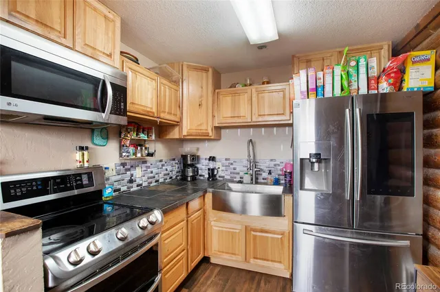 a kitchen with stainless steel appliances granite countertop a refrigerator stove and sink