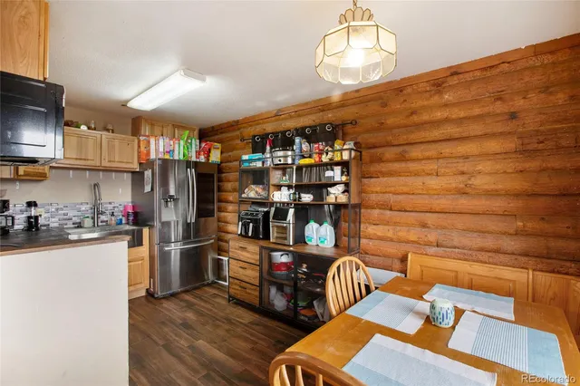 a kitchen with stainless steel appliances wooden floor and a refrigerator
