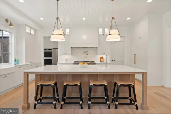 a large kitchen with kitchen island a stove a sink a center island and couches