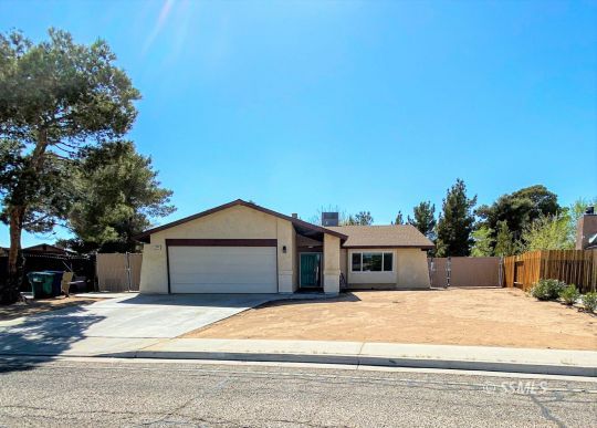 205 Kimberly Lane Ridgecrest, CA 93555 - Photo 1 of 39 a front view of a house with a garden
