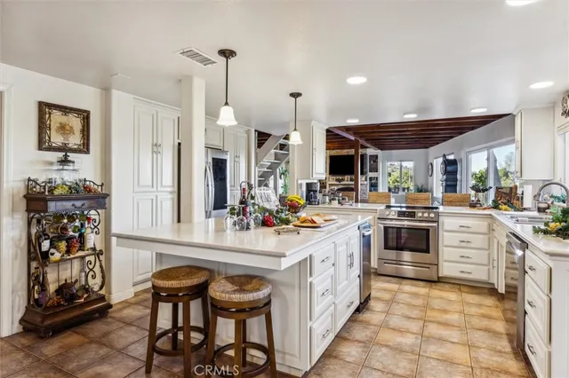a kitchen that has a lot of cabinets in it and wooden floors