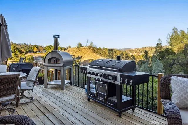 a backyard of a house with table and chairs under an umbrella