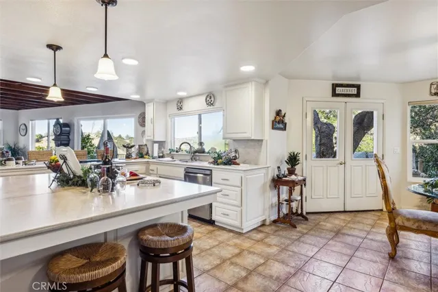 a view of dining room kitchen with stainless steel appliances granite countertop a sink a stove a dining table and chairs