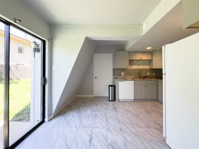 a kitchen with granite countertop a sink and a refrigerator