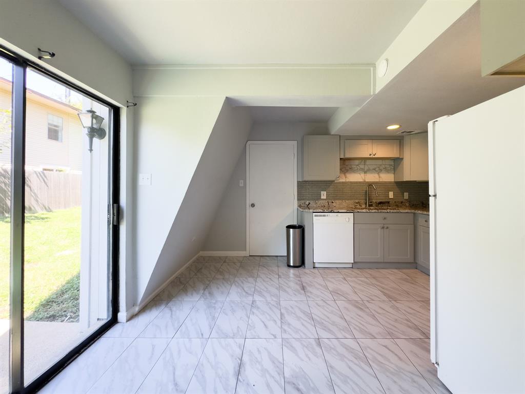 a kitchen with granite countertop a sink and a refrigerator