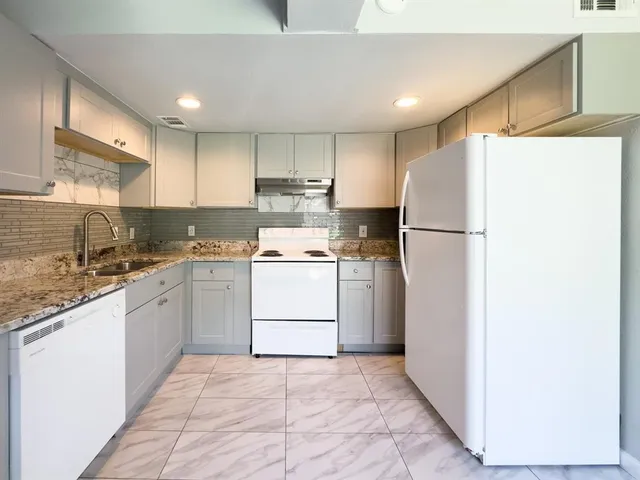 a kitchen with a refrigerator a sink and cabinets