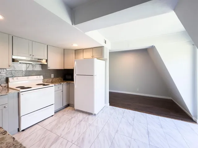 a kitchen with a refrigerator sink stove and cabinets