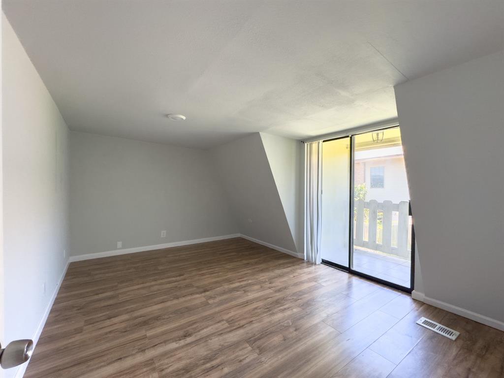 1308 Cordell Street, Unit 1 Denton, TX 76201 - Photo 9 of 10 an empty room with wooden floor and windows
