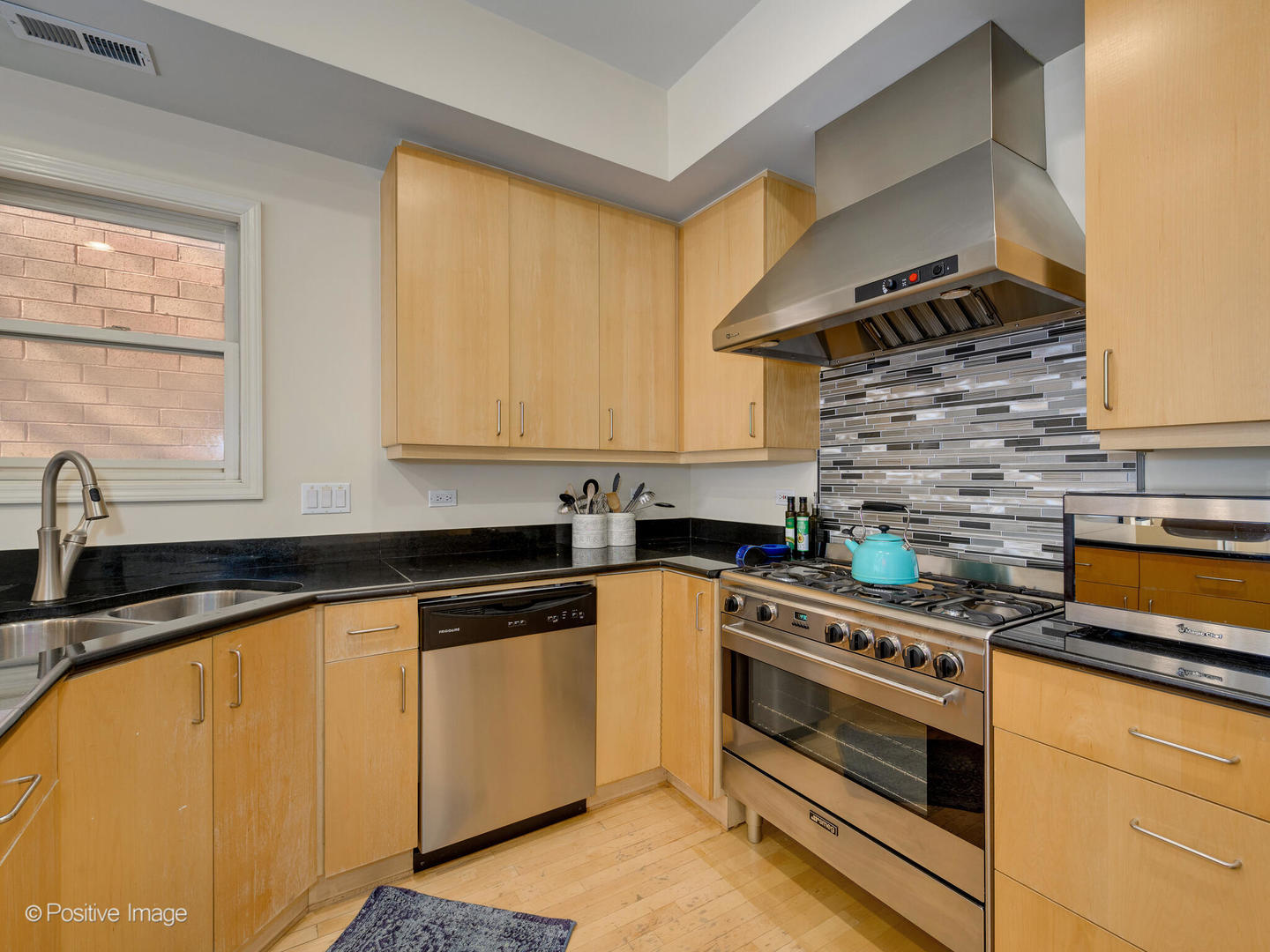 1829 North Mohawk Street, Unit 2N Chicago, IL 60614 - Photo 9 of 16 a kitchen with granite countertop a stove a sink and a microwave