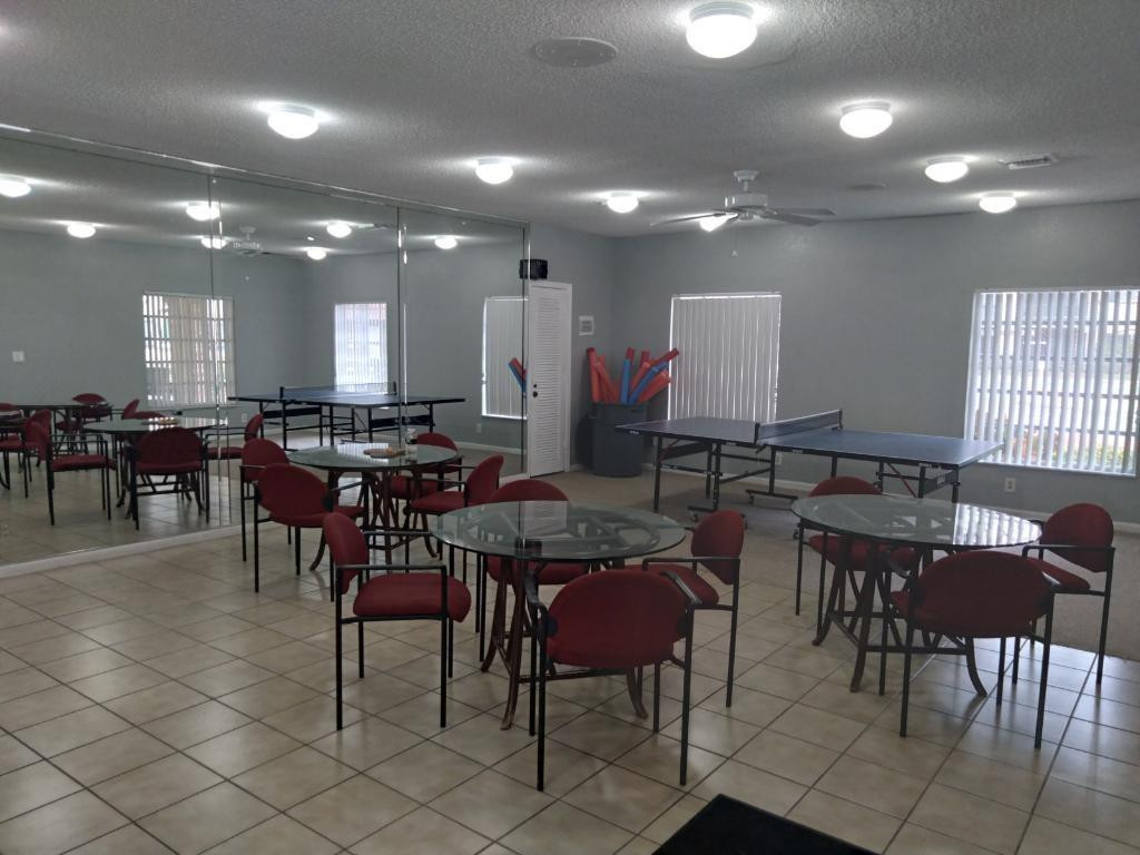 257 South Cypress Road, Unit 423 Pompano Beach, FL 33060 - Photo 35 of 38 a group of people sitting in a large dining room with kitchen view