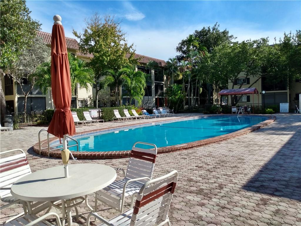 257 South Cypress Road, Unit 423 Pompano Beach, FL 33060 - Photo 38 of 38 a swimming pool with outdoor seating and yard