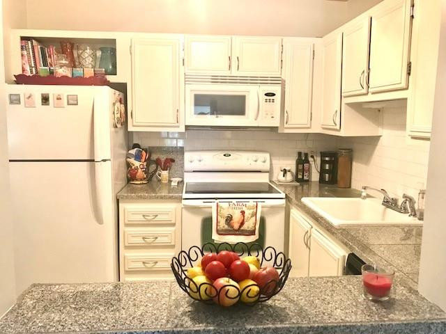 257 South Cypress Road, Unit 423 Pompano Beach, FL 33060 - Photo 7 of 38 a kitchen with a refrigerator a stove a sink and cabinets