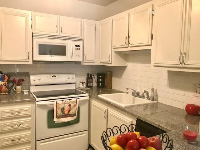 257 South Cypress Road, Unit 423 Pompano Beach, FL 33060 - Photo 9 of 38 a kitchen with stainless steel appliances granite countertop a sink and a stove