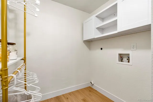 a view of a closet area with wooden floor