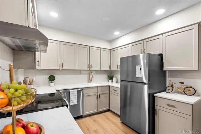 a kitchen with a sink a refrigerator and cabinets