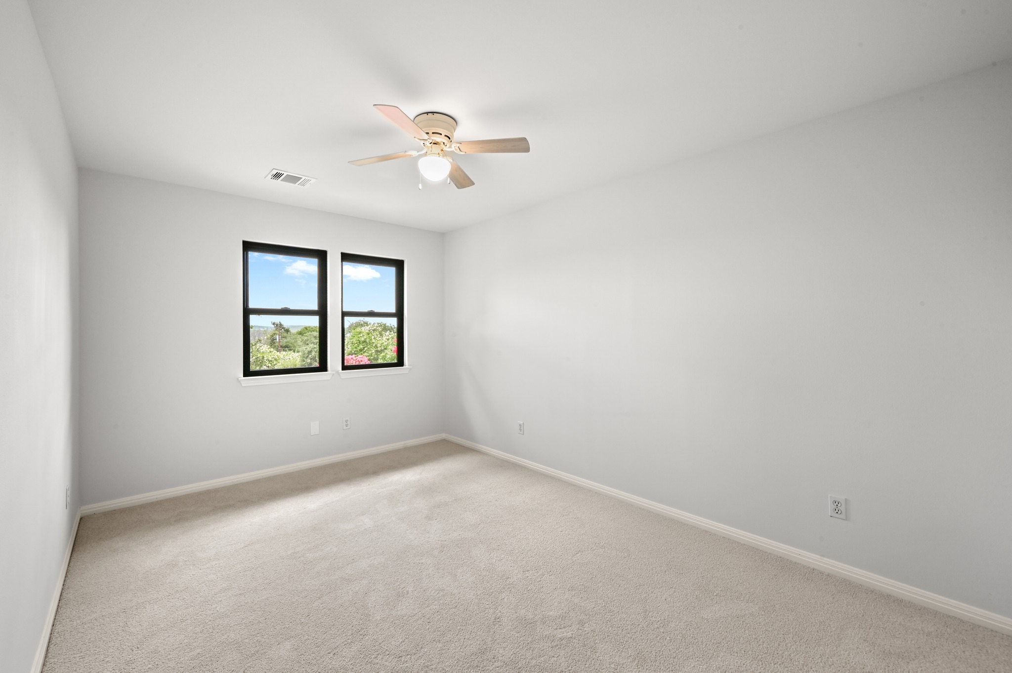 1107 Bowie Road Austin, TX 78733 - Photo 31 of 40 A well-lit bedroom features plush carpeting and a ceiling fan, ready for personal touches.