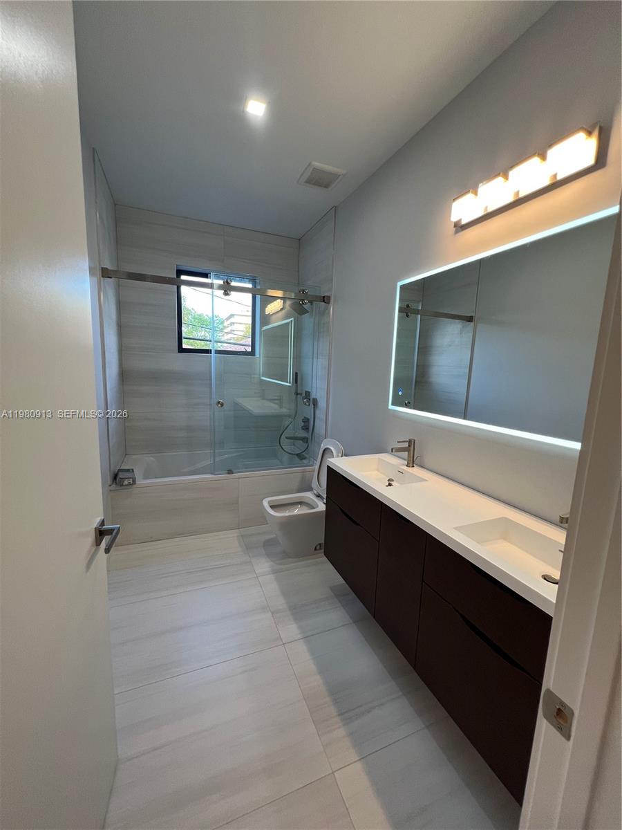 1533 Southwest 22nd Terrace Miami, FL 33145 - Photo 22 of 28 a bathroom with a bathtub and a double vanity sink