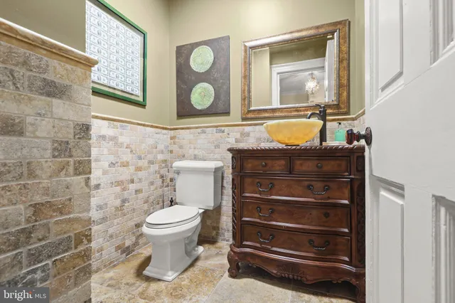 a bathroom with a granite countertop toilet sink and mirror
