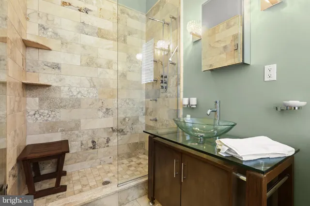 a bathroom with a granite countertop sink a toilet and shower