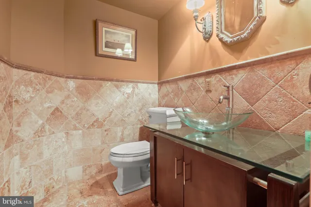 a bathroom with a granite countertop sink and a toilet