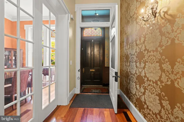 a view of a hallway with wooden floor and a bathroom