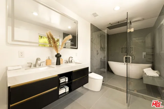 a bathroom with a double vanity sink toilet and shower