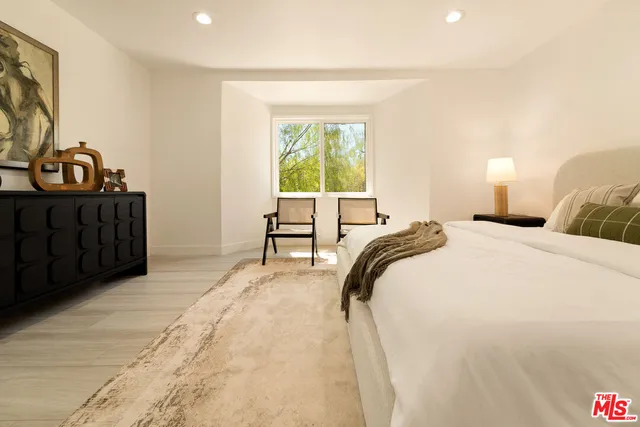 a bedroom with a bed and a potted plant