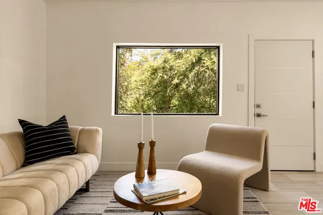 a living room with a large window and a wooden floor