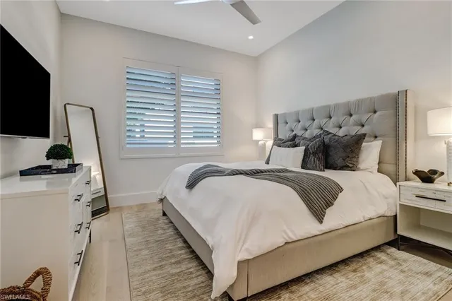 a bedroom with bed and a flat tv screen on dresser