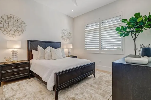 a bedroom with a bed and a potted plant