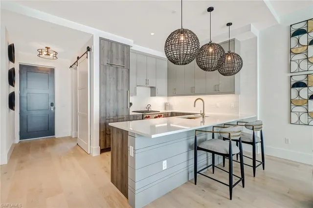 a kitchen with a sink a cabinets and chairs in it