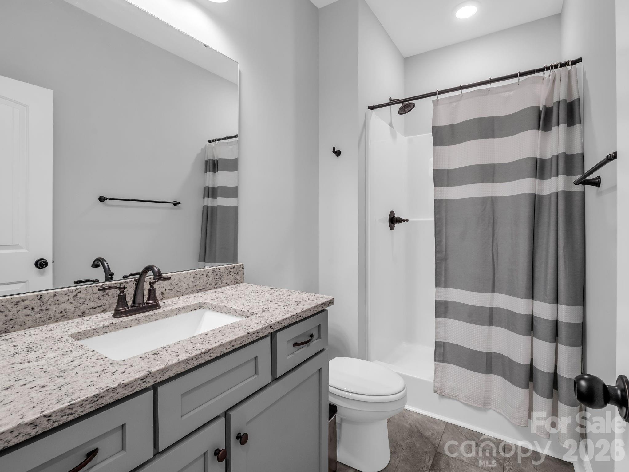 631 Mountain Parkway Mill Spring, NC 28756 - Photo 15 of 43 a bathroom with a granite countertop sink toilet and shower