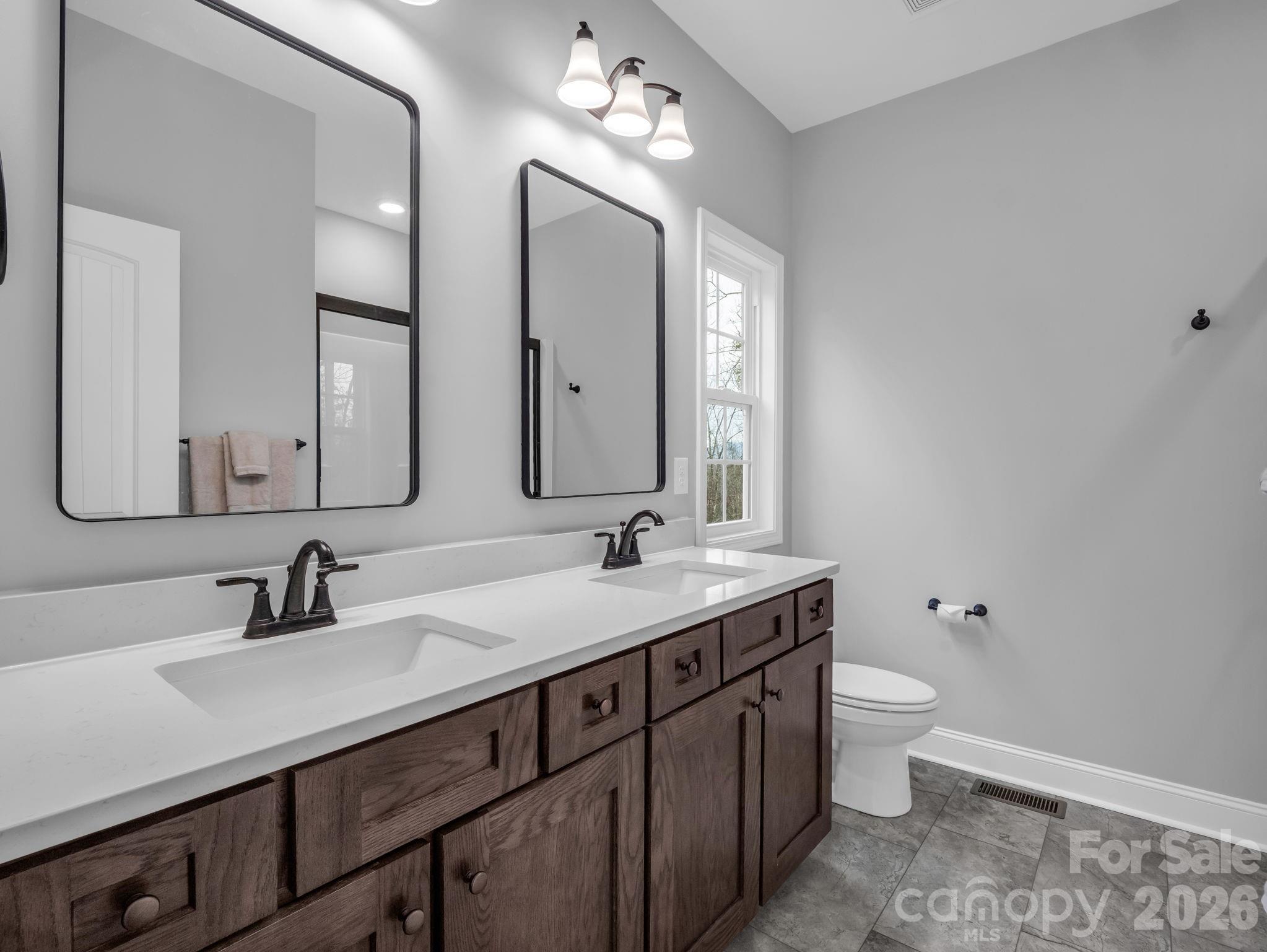 631 Mountain Parkway Mill Spring, NC 28756 - Photo 19 of 43 a bathroom with a double vanity sink and a mirror