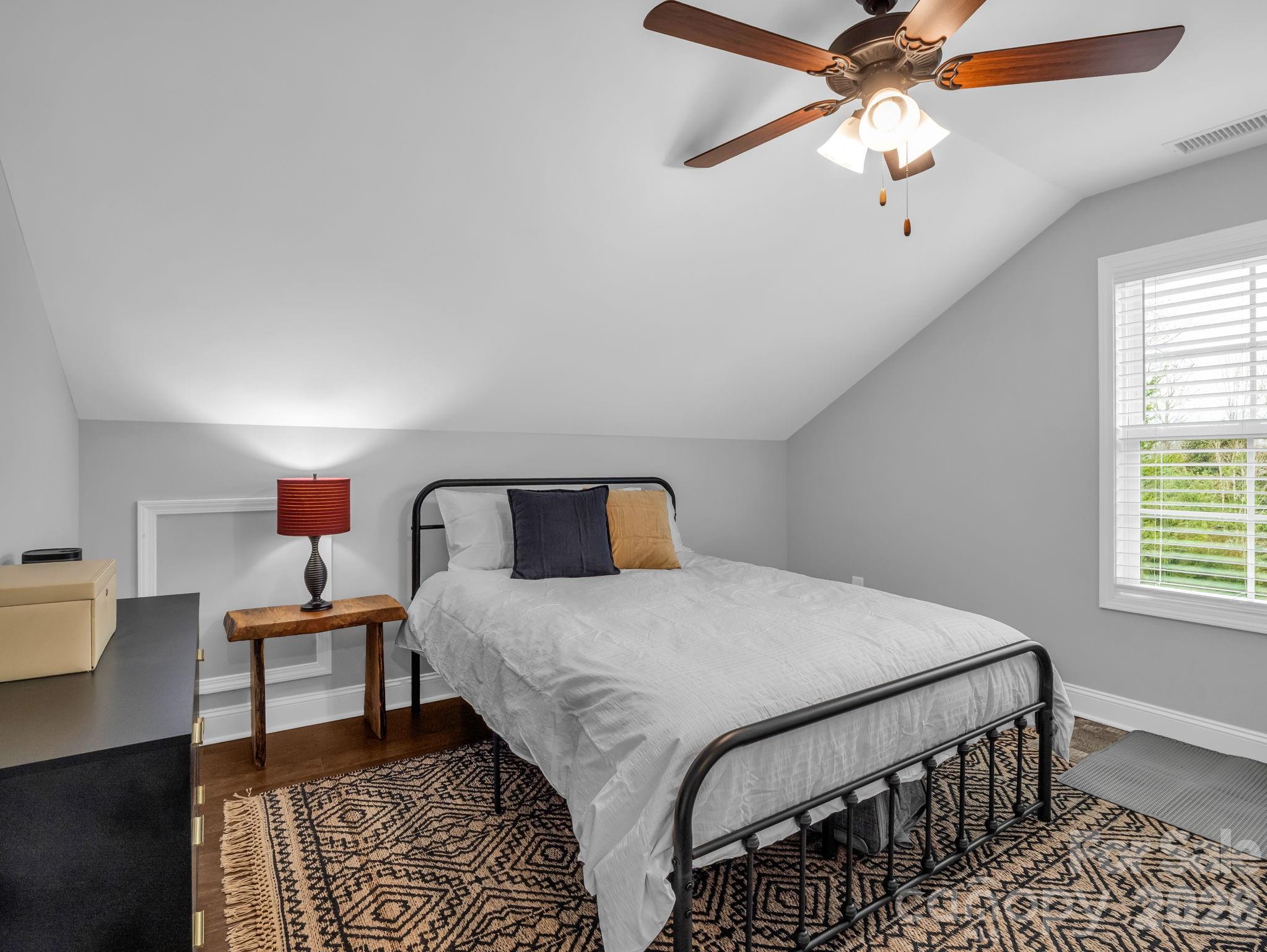 631 Mountain Parkway Mill Spring, NC 28756 - Photo 25 of 43 a bedroom with a bed and a chandelier