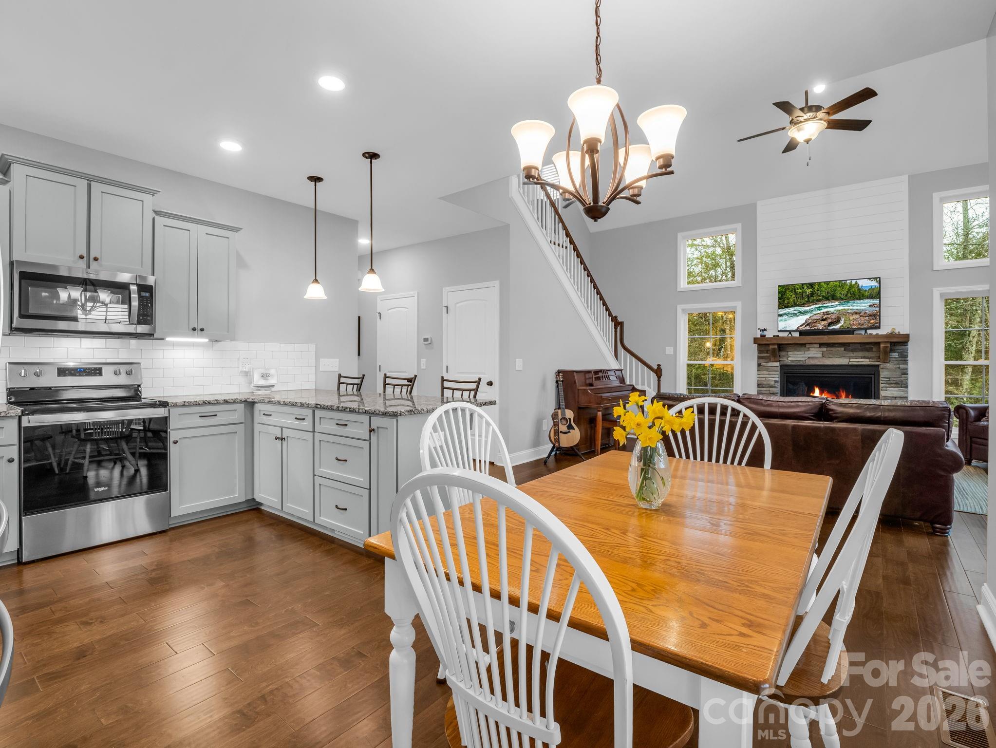631 Mountain Parkway Mill Spring, NC 28756 - Photo 10 of 43 a kitchen with stainless steel appliances granite countertop a stove top oven a sink a dining table and chairs with wooden floor