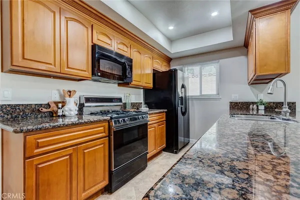 a kitchen with stainless steel appliances granite countertop a stove a sink and a microwave