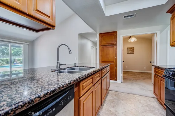 a kitchen with granite countertop a sink and a stove