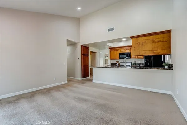a view of kitchen with refrigerator stove and cabinets