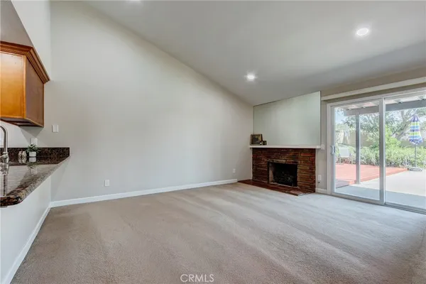 a view of an empty room with a fireplace and a window