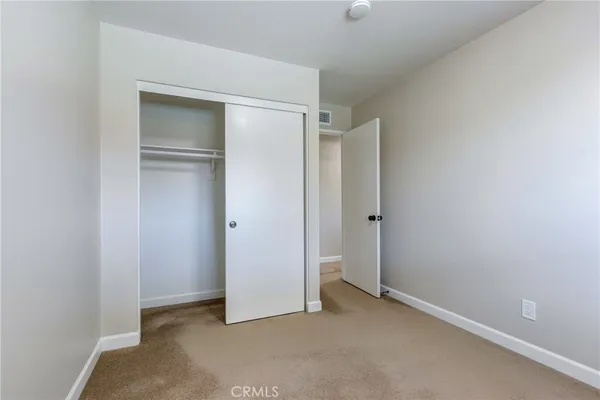 an empty room with closet and a bathroom