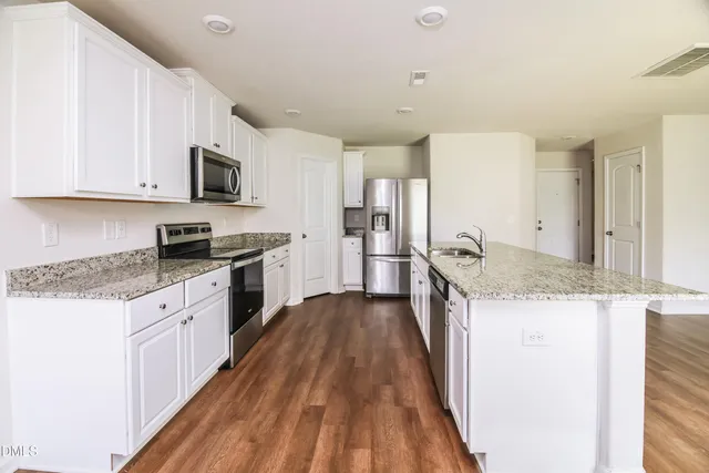 a kitchen with granite countertop a sink and steel appliances