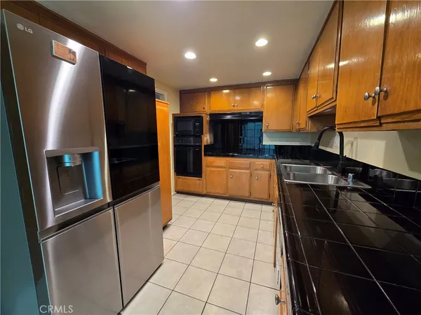 a kitchen with stainless steel appliances granite countertop a refrigerator and a sink