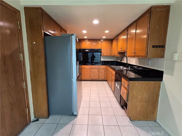 a kitchen with stainless steel appliances granite countertop a refrigerator and a sink