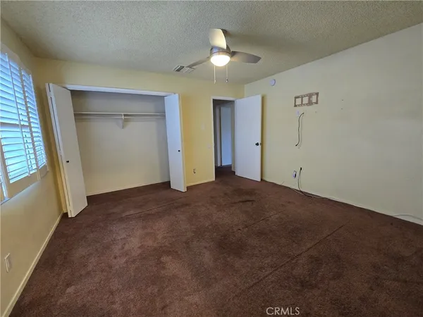 a view of an empty room and a ceiling fan