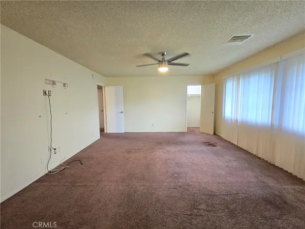 an empty room with fan and windows