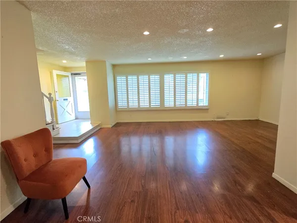 a view of a livingroom with furniture wooden floor and a window
