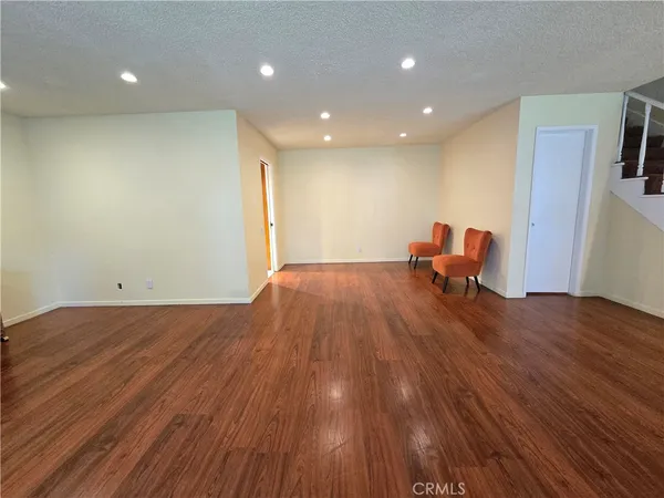 a view of a livingroom with wooden floor and furniture